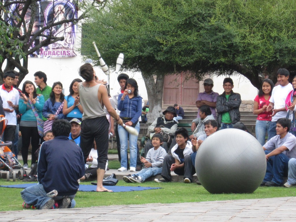Locals gather to watch a street performer in Cusco's Plaza de San Francisco