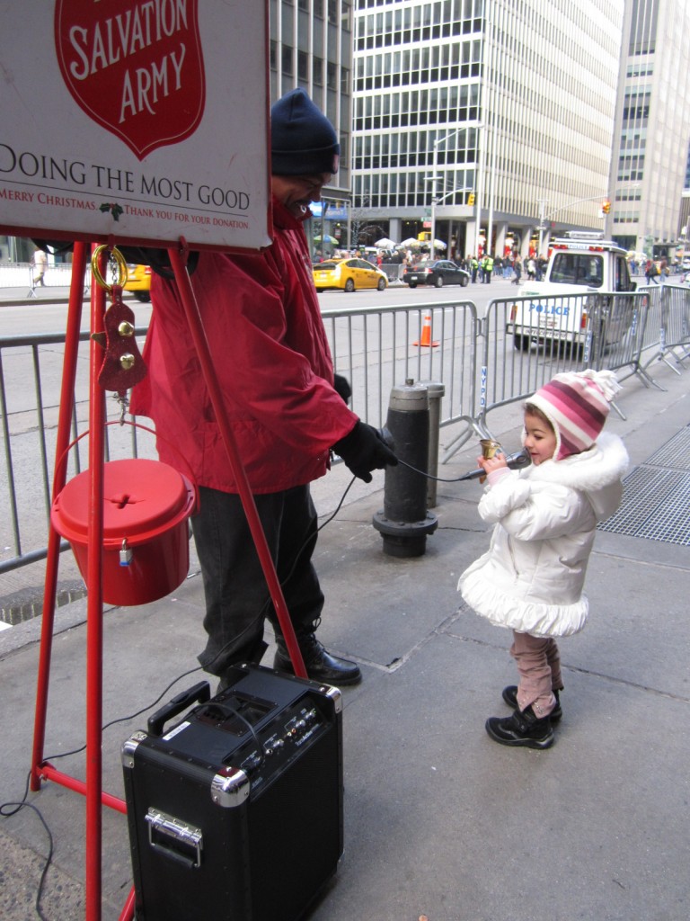 A young girl sings "Jingle Bells" for shoppers along the Avenue of the Americas