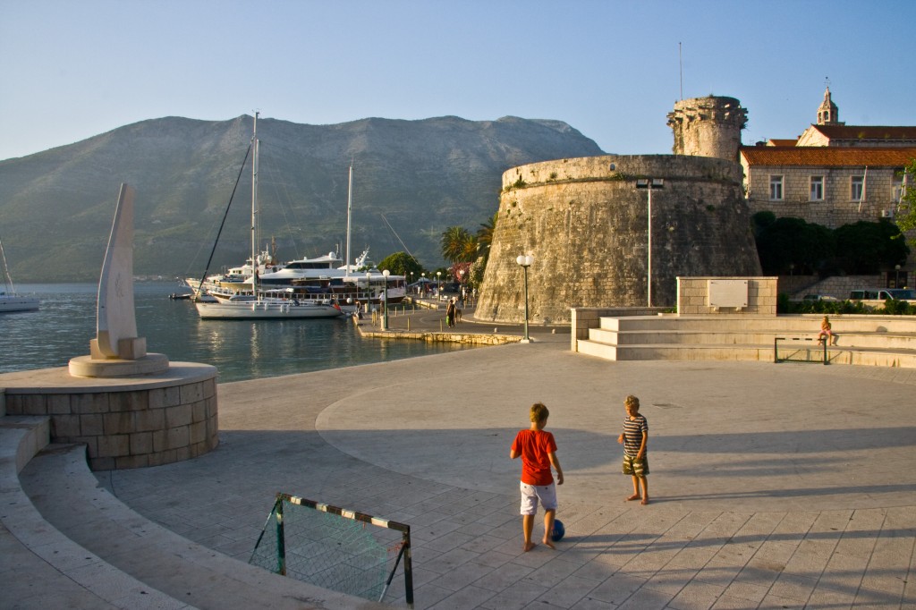 Little boys play football as the sun sets on the Croatian island of Korcula